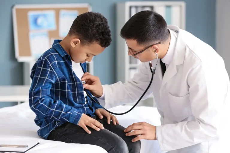 A doctor listens to a child's chest with a stethoscope during a medical examination.