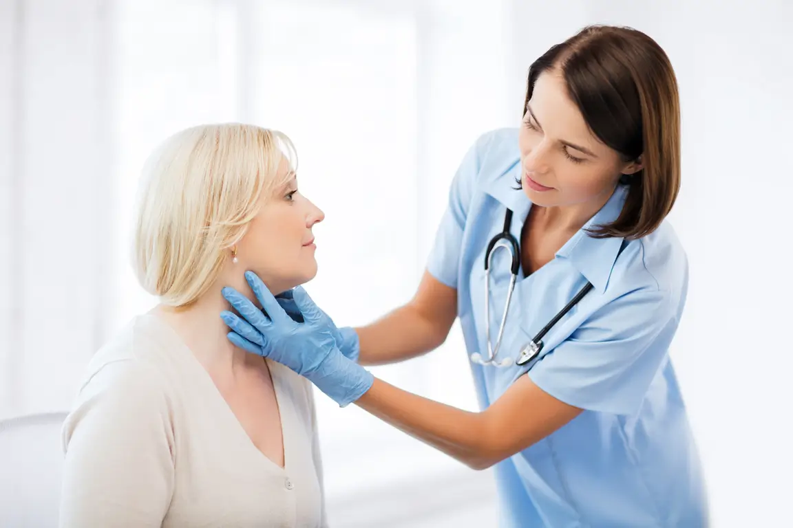 A woman undergoing a medical examination by a doctor in a clinical setting.