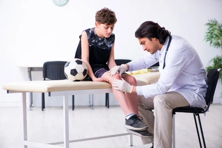 Physician Assessing A Child’s Knee Injury In A Clinic